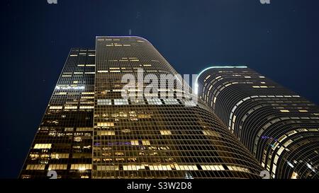 LOS ANGELES, CA, FEBBRAIO 2022: Guardando verso l'alto i grattacieli gemelli di uno e due California Plaza di notte, gli uffici illuminati di notte nel quartiere finanziario del centro Foto Stock