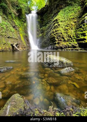 Sgwd Enion Gam (cascata dell'incudine storta), Afon Pyrddin, Brecon Beacons, Galles. Foto Stock