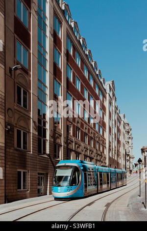 Un tram della metropolitana delle West Midlands su una strada di Birmingham City con architettura storica e antica con spazio copia Foto Stock