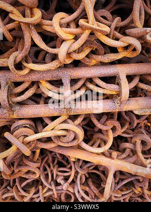 Catene e ganci arrugginiti “provati e arrugginiti” mettono in evidenza le tensioni degli attrezzi da pesca, la dura vita in mare Foto Stock