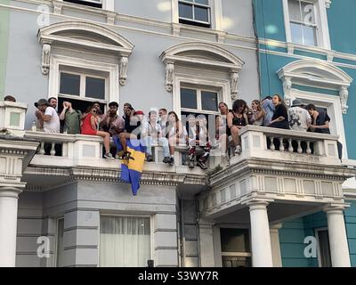 Persone sedute sul balcone di Notting Hill carnevale Londra Foto Stock