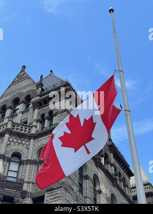 Bandiera canadese che vola a mezza altezza nel vecchio municipio di Toronto. Toronto, Ontario. Foto Stock