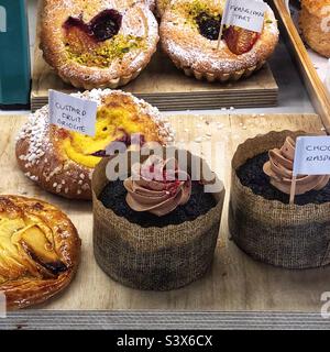 Brioche alla frutta, crostata di Frangipane e torte assortite nella vetrina del panificio Foto Stock