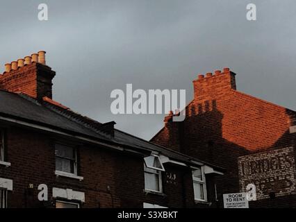 Lato di un edificio a muro in mattoni alla luce della sera contro un cielo sovrastante in Bromley Londra Inghilterra Foto Stock