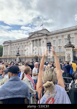 La donna fotografa la folla di lutto fuori Buckingham Palace il giorno dopo la morte della regina Elisabetta II. Foto Stock