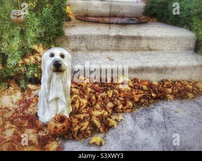 Anche un simpatico cucciolo fantasma vuole ingannare o trattare. Si trova al portico anteriore di una casa Utah, USA come parte della loro decorazione cortile ogni anno durante ottobre e la stagione di Halloween. Foto Stock