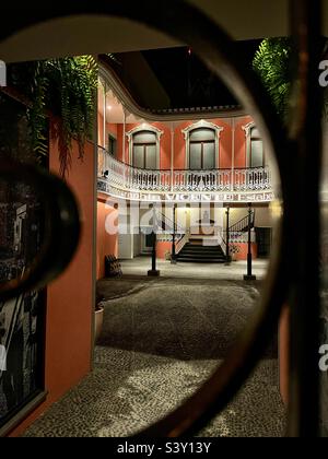 Guardando attraverso le porte del Museo della Fotografia a Funchal, Madeira. Museu de Fotografia da Madeira di notte - questo bellissimo edificio è illuminato Foto Stock