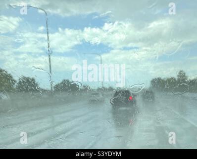 Guida attraverso un defluente monsonale su un'autostrada dello Utah, Stati Uniti verso la fine dell'estate. Il parabrezza e la strada accumulano acqua rapidamente, rendendo difficile la visualizzazione e la navigazione. Tutto sta saltando bagnato. Foto Stock