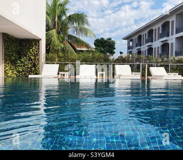 Sedie a sdraio presso la piscina dell'hotel Foto Stock