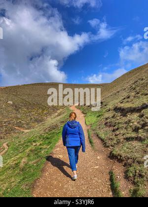 Donna che cammina sul sentiero costiero Cappella Porth Cornovaglia Foto Stock