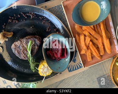 Filetto argentino servito con verdure alla griglia e patatine fritte dolci Foto Stock