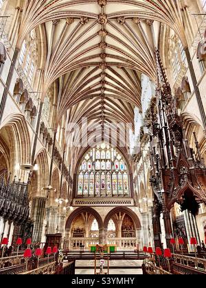 All'interno della cattedrale di Exeter, uno splendido luogo di culto per la Chiesa d'Inghilterra con una magnifica navata e un dettagliato soffitto architettonico intagliato con un'enorme vetrata sopra l'altare Foto Stock