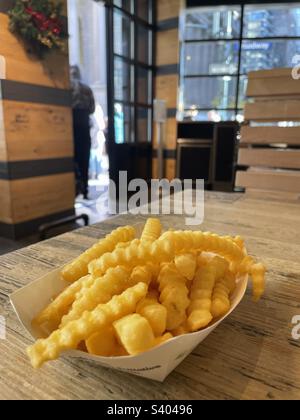 Un cestino di patatine fritte aggiungere un ristorante shack shake Foto Stock