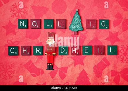 Piastrelle di legno verdi e rosse che scrivono Nollaig Chridheil. Foto Stock