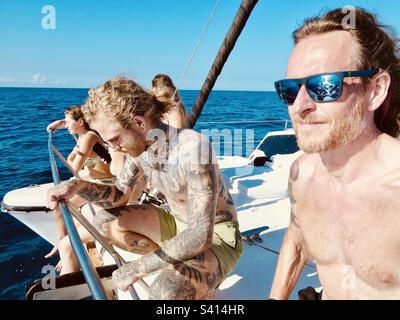 I viaggiatori amano sedersi sul ponte di un catamarano in una giornata perfetta in Costa Rica Foto Stock