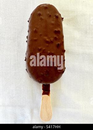 Gelato alla vaniglia rivestito di cioccolato su un bastoncino Foto Stock
