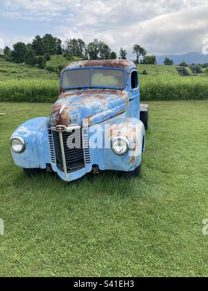 Vecchio stile, camion pick up blu nel Vermont USA Field. Il veicolo è arrugginito nei punti. Foto Stock