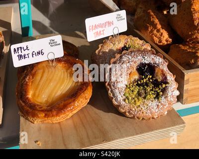 Crostata di mele fine e crostata di Frangipane nella vetrina del panificio Foto Stock