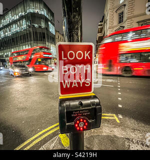 Londra attraversamento pedonale "Look both ways" segno notte Foto Stock