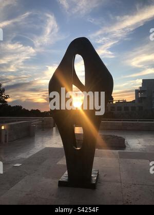 Il sole tramonta attraverso la figura per il paesaggio, di Barbara Hepworth, ora nel giardino delle sculture del Getty Center a West Los Angeles, California. Foto Stock