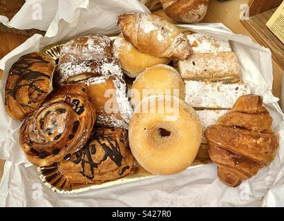 Diversi tipi di torte e dolci come ciambelle e brioche Foto Stock