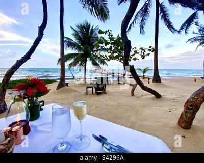 Cena al tramonto con champagne in spiaggia Foto Stock