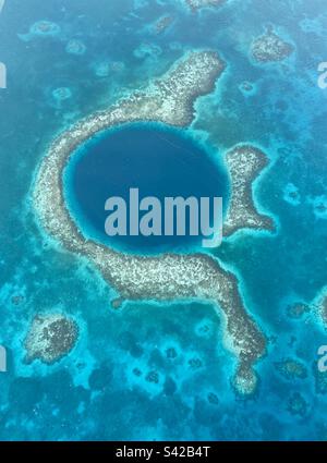 La vista aerea del bellissimo Great Blue Hole è una gigantesca sinkhole nel centro di Lighthouse Reef, parte del Belize Barrier Reef Reserve System Foto Stock