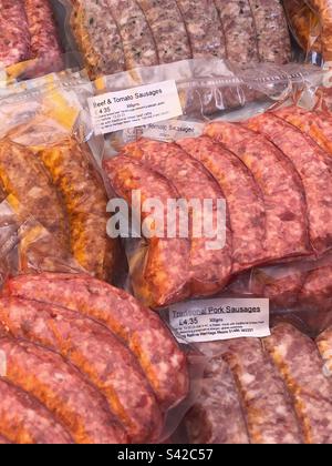 Salsicce speciali di manzo e pomodoro e salsicce tradizionali di maiale in vendita presso il mercato agricolo locale Foto Stock