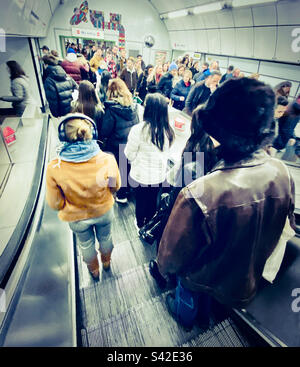 Persone su una scala mobile che scendono fino alla metropolitana di Londra Foto Stock