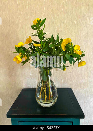 Vaso in vetro con fiori gialli invernali Foto Stock