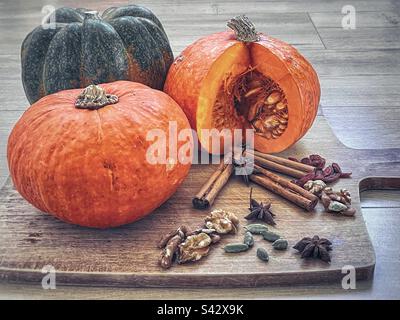 Primo piano di zucche, spezie e noci sul tagliere sul tavolo. Foto Stock