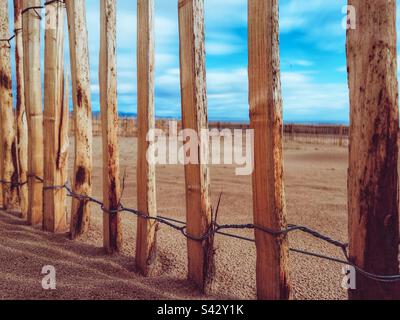 Recinzione in legno sulla spiaggia Foto Stock