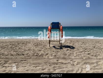 Sedia bagnino su una spiaggia deserta in una soleggiata primavera mattina Foto Stock