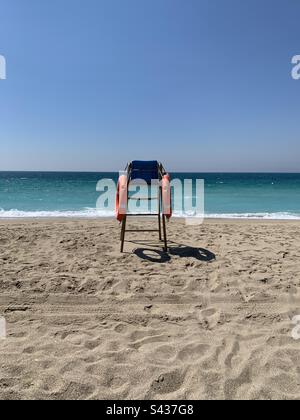 Sedia bagnino su una spiaggia deserta in una soleggiata primavera mattina Foto Stock