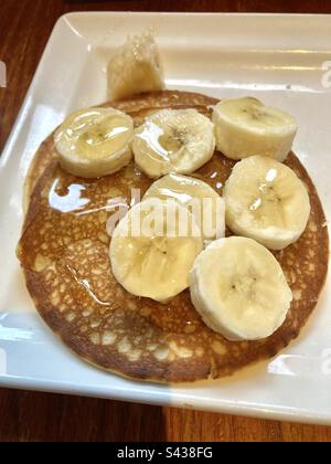 Sciroppo e pancake con banana per colazione Foto Stock