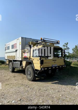 Camion di spedizione uomo parcheggiato sull'isola di Hiiumaa, Estonia sul mare. Foto Stock