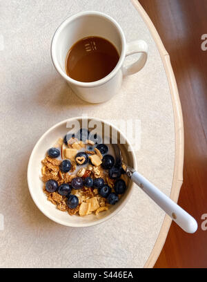 In una ciotola di cereali con mirtilli e noci, latte di mandorla e una forma a cuore su un mirtillo, il glutine sano libera fiocchi e forme. Serendipity autentico. Foto Stock