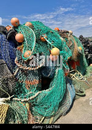 Reti da pesca e boe accumulate sul lato del porto a Lyne Regis, Dorset, Inghilterra Foto Stock