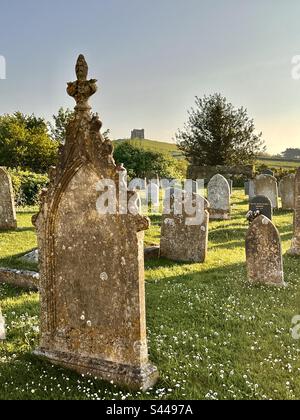 Tipico cimitero inglese villaggio con pietre arancio e vecchie nel caldo sole estivo, Abbotsbury, Dorset, Inghilterra Foto Stock