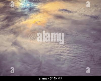 Cielo spettacolare con luna piena e nuvole iridescenti nel cielo mattutino a causa di minuscoli cristalli di ghiaccio nell'aria che causano la diffrazione o la diffusione della luce. Full frame. Sfondi. Astratto. Foto Stock