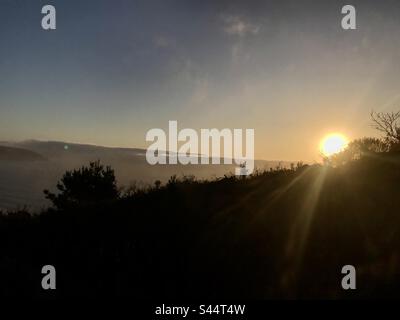 ahí estaba yo, en mi cita una vez más… en mi cita camino al atardecer con el mar. Foto Stock