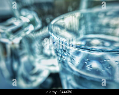 Primo piano di un bicchiere d'acqua. Enfasi macro sul bordo del vetro. Foto Stock