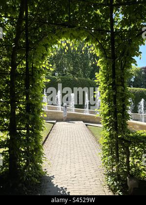 L'arco di vita del Giardino di Alnwick, che si affaccia sulle fontane con una bambina di 8 anni che le guarda Foto Stock