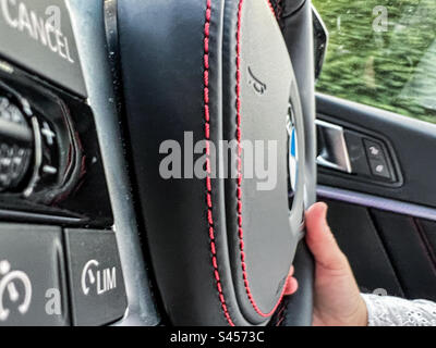 Guida di un'auto BMW con un primo piano del volante M Sport Foto Stock