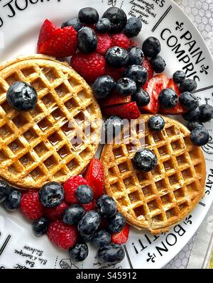Waffle e frutta fresca estiva di mirtilli, lamponi, fragole con sciroppo d'acero canadese per una colazione gréât. Foto Stock