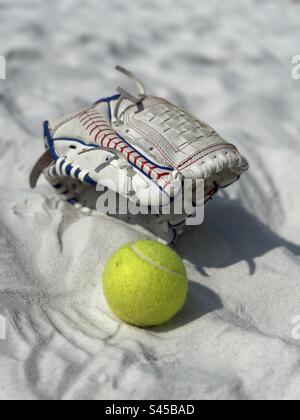 Guanto da baseball e palla sulla sabbia bianca della spiaggia Foto Stock