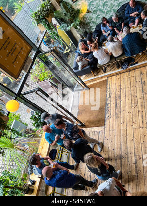 Persone che si divertono all'interno di un bar affollato nel centro di Leeds Foto Stock