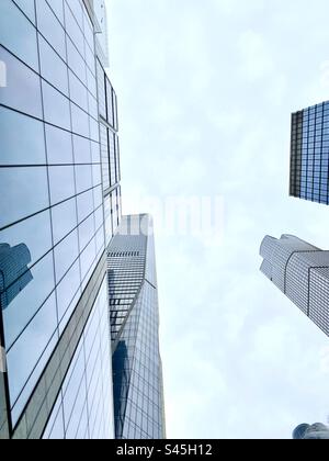 Guarda il cielo tra i grattacieli di vetro di New York Foto Stock