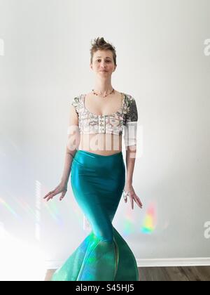 Donna vestita con coda a sirena con copertura picc line e luce arcobaleno Foto Stock