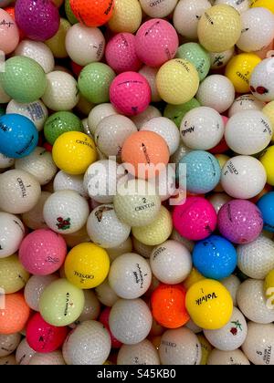 Una collezione di centinaia di palline da golf colorate. Foto Stock